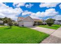 View of single-story home featuring a well-manicured lawn and a two-car garage at 2223 Fairmont Cir, Orlando, FL 32837