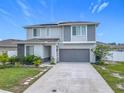 Charming home showcasing a two-car garage, well-kept lawn, and contemporary architectural details at 242 White Heron Way, St Cloud, FL 34772