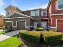 Inviting townhouse exterior with well-maintained landscaping, attached garages, and modern color palettes on a sunny day at 2918 Rodrick Cir, Orlando, FL 32824