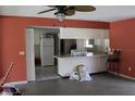 Open floor plan to kitchen featuring salmon colored walls and ceiling fan at 305 E Orange St, Altamonte Springs, FL 32701