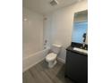 A clean bathroom features a standard tub and a stylish vanity with a dark countertop at 3213 Energy Dr, Kissimmee, FL 34747