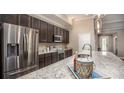 Modern kitchen featuring stainless steel appliances, granite countertops, dark cabinets and an island at 345 S Sunset Ave, Mascotte, FL 34753