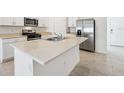 Modern kitchen featuring white cabinetry, an island with countertop seating, and stainless steel appliances at 4709 Jasmine Cir, Leesburg, FL 34748