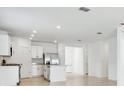 Bright, airy kitchen with white cabinets, stainless steel appliances, and an island with countertop seating at 4709 Jasmine Cir, Leesburg, FL 34748