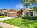 Charming single-story home with a two-car garage, beautiful landscaping, and a well-manicured lawn at 5431 Lochdale Dr, Orlando, FL 32818