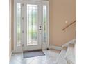 Bright foyer featuring decorative glass front door, tile flooring, and staircase at 600 Egret Place Dr, Winter Garden, FL 34787