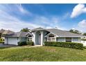 Inviting single-story home with blue paint, arched windows, and a well-kept front lawn at 9108 N Bay Boulevard, Orlando, FL 32819