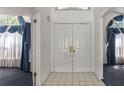 Bright foyer with tile flooring, double front doors, and views of rooms with elegant window treatments at 9108 N Bay Boulevard, Orlando, FL 32819