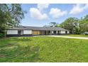 Lovely home exterior with a well-manicured lawn and trees at 11540 Harbor Rd, Leesburg, FL 34788