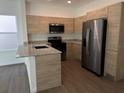 Well-lit kitchen with stainless steel appliances, granite countertops, and wood-style cabinets at 1205 Southstation Pl # 208, Orlando, FL 32809