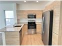 Bright kitchen with stainless steel appliances, granite countertops, and wood-style cabinetry at 1205 Southstation Pl # 208, Orlando, FL 32809