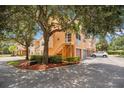 Three-story townhome with stairs to the second level, manicured landscaping, and assigned parking at 12414 Baleria Cv # 104, Orlando, FL 32837