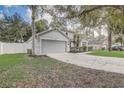 View of the home featuring an attached garage, landscaped yard, and classic design details at 1307 Pup Fish Ln, Deland, FL 32724