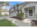 View of the home highlighting a two-car garage, landscaped entrance and covered front door at 1307 Pup Fish Ln, Deland, FL 32724
