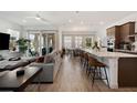 Spacious living area with tile floors, a modern sectional sofa, and an open floor plan to the kitchen at 13208 Leggett Aly, Orlando, FL 32827