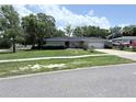 Well-kept single-story home with lush green lawn, a concrete driveway and mature trees at 1326 Wildcat Ct, Apopka, FL 32712