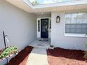 Inviting front entry with a wreath on the door and colorful flowers hanging to the side at 1326 Wildcat Ct, Apopka, FL 32712