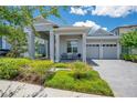 Charming home with a two-car garage, covered porch with ample seating, and paver driveway at 14189 Larkspur Lake Dr, Winter Garden, FL 34787