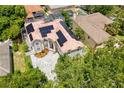 Aerial view of a two-story home featuring solar panels, a red tile roof, and a paved driveway at 1706 Cheltenborough Dr, Orlando, FL 32835