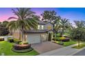 Beautiful two-story home featuring a lush landscaped yard, brick driveway, and a three-car garage at 1938 Filly Trl, Oviedo, FL 32765