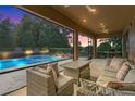 Relax in this covered outdoor space with comfortable seating, a grill and views of the pristine pool and backyard at 1938 Filly Trl, Oviedo, FL 32765