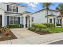 Townhouse exterior featuring a driveway, manicured shrubs, and covered entrance at 2531 Maneshaw Ln, Kissimmee, FL 34747