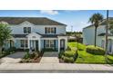 Light blue two-story townhouse with a manicured garden and dark shutters at 2531 Maneshaw Ln, Kissimmee, FL 34747