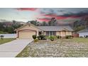 Charming single-story home with well-manicured landscaping and a two-car garage under dramatic sky at 2741 Beaver Dr, Deltona, FL 32725