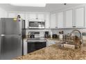 A kitchen with white cabinets, stainless steel appliances and granite countertops at 3023 S Atlantic Ave # 2050, Daytona Beach, FL 32118