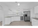 Bright kitchen with stainless steel appliances, granite countertops, and white cabinets at 446 Arkansas Ct, Poinciana, FL 34759