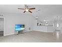 Open-concept living room featuring vaulted ceilings and a stylish ceiling fan with tile flooring at 446 Arkansas Ct, Poinciana, FL 34759