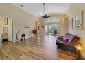 Spacious living room with wood-look flooring, ceiling fan, and sliding glass doors at 4533 Oakbrook Ct, Kissimmee, FL 34746