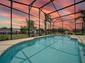 A beautiful, screened-in pool with a serene backyard view, perfect for relaxation and entertaining at 456 Old Bridge Cir, Davenport, FL 33897