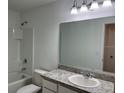 Bright bathroom with a vanity, a large mirror, and a shower-tub combination, designed for comfort and functionality at 477 Madison Dr, Davenport, FL 33837