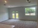 Open-concept living room featuring plush carpeting, recessed lighting, and an abundance of natural light at 497 Madison Dr, Davenport, FL 33837