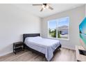 A minimalist bedroom with a comfortable bed, a wooden floor, and a scenic outdoor view at 5677 Cedar Chase Dr, St Cloud, FL 34771