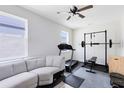Bright bonus room featuring a ceiling fan, a gray sectional, and home fitness equipment at 5677 Cedar Chase Dr, St Cloud, FL 34771