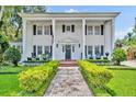 Elegant exterior of a white two-story home with large columns, brick walkway, and well-maintained landscaping at 624 Richmond Street, Orlando, FL 32806