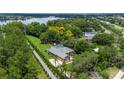 Aerial view of a sprawling property featuring a large home, lush landscaping, and a serene lake nearby at 6720 Winter Garden Vineland Rd, Windermere, FL 34786