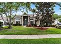 Beautiful home showcasing a lush green lawn, mature trees, and a welcoming front entrance at 806 Spring Island Way, Orlando, FL 32828
