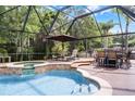 Enjoy a screened pool with a spa, lounge chairs and dining table and chairs at 806 Spring Island Way, Orlando, FL 32828