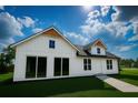 New modern farmhouse with white siding, black roof, with an inviting entry and manicured lawn at 9659 Midway Rd, Haines City, FL 33844