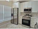 Modern kitchen with stainless steel appliances, white cabinetry, and ample natural light from the window at 13546 Summerton Dr, Orlando, FL 32824