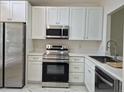 Bright kitchen featuring white cabinets, stainless steel appliances, and countertops for a modern and clean look at 13546 Summerton Dr, Orlando, FL 32824