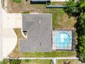 Overhead view of house with screened-in pool and neutral colored roof at 1736 Saxon Blvd, Deltona, FL 32725