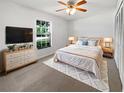 Cozy bedroom with a queen-sized bed, soft carpet, dresser, and a view of the outdoors at 1818 Portview Ave, Deltona, FL 32738