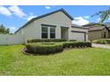 Well-maintained home with green lawn and manicured landscaping around the entrance and windows at 2210 Romanum Dr, Winter Garden, FL 34787