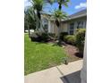 Well-manicured front yard with mature plants and mulch beds at 2421 Queenswood Cir, Kissimmee, FL 34743