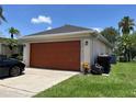Side view of the two car garage and long driveway at 2421 Queenswood Cir, Kissimmee, FL 34743