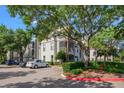 Well-maintained exterior of a condominium building with ample parking and mature landscaping around the property at 2525 Maitland Crossing Way # 202, Orlando, FL 32810
